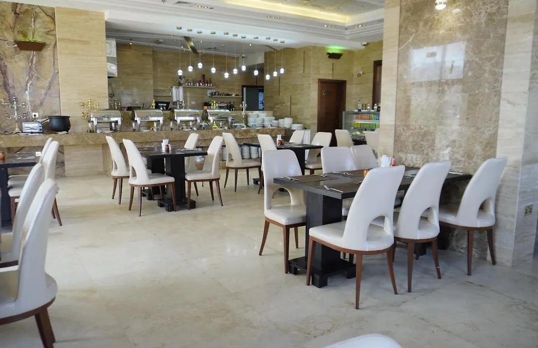 Dining hall set with rows of tables and cream chairs under a coffered ceiling