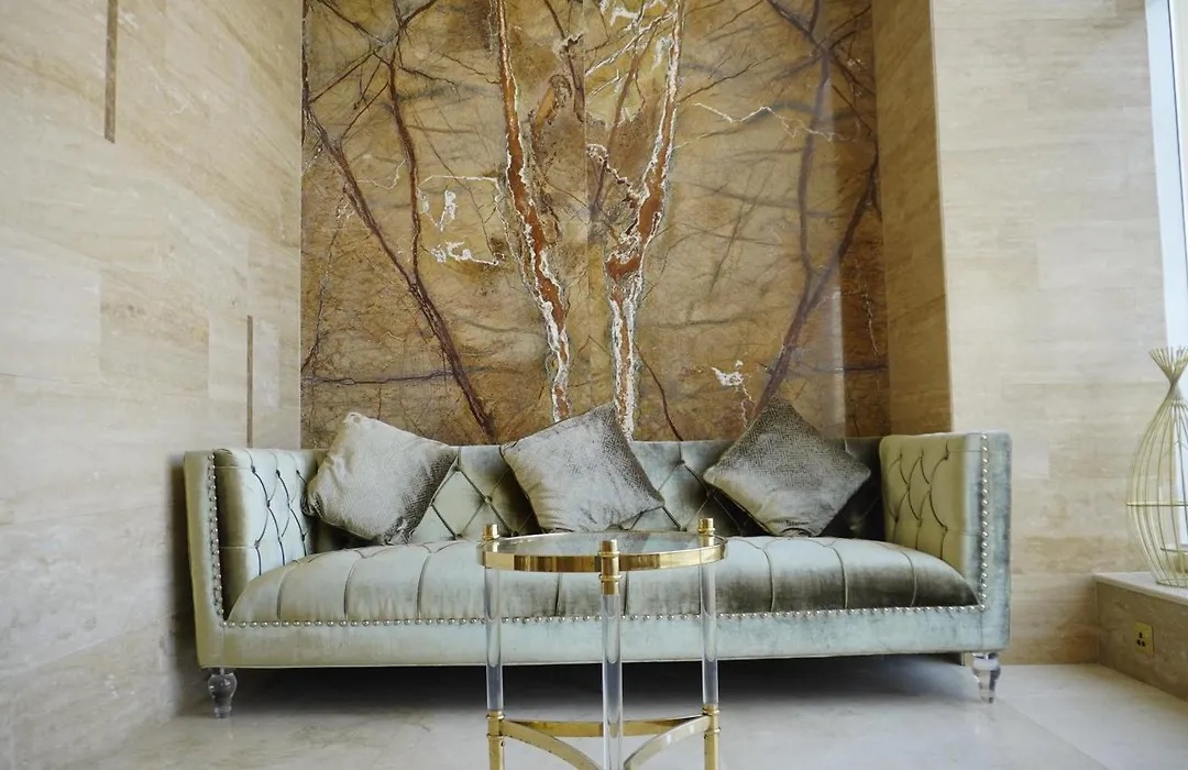 Lobby lounge with a gold sofa against a marble wall