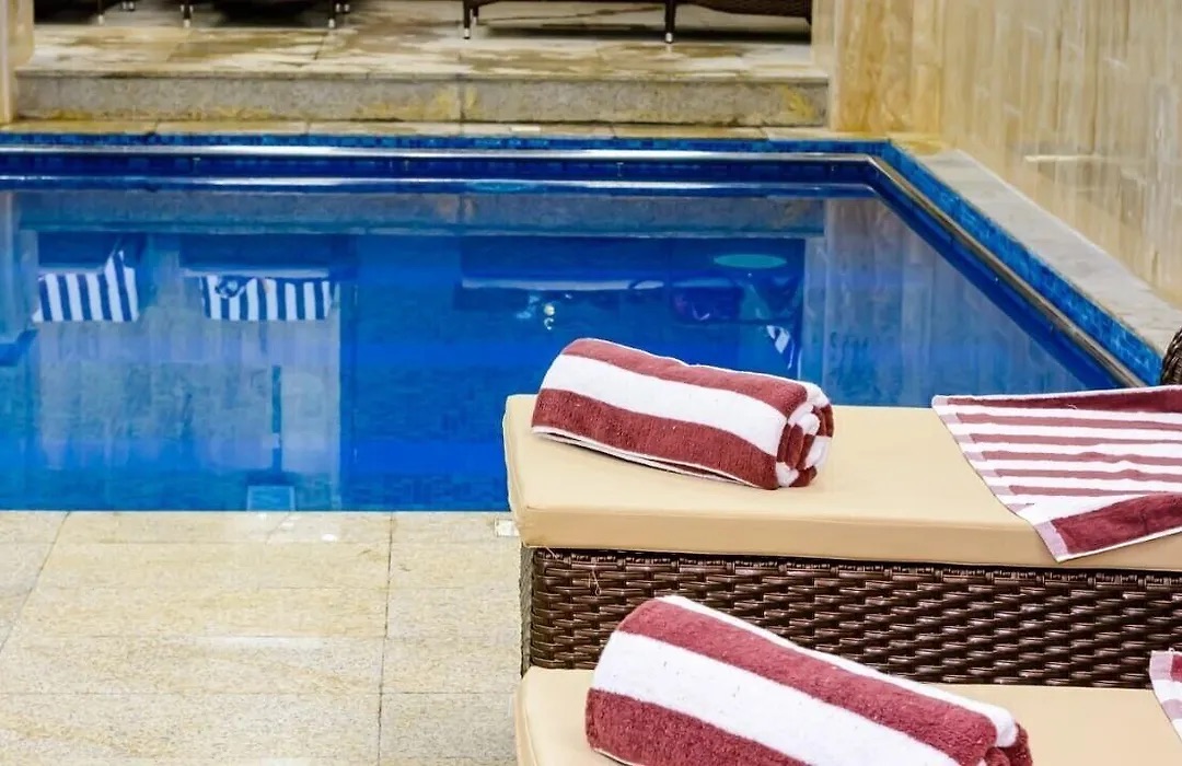 Indoor pool with a basket of striped towels on a lounger