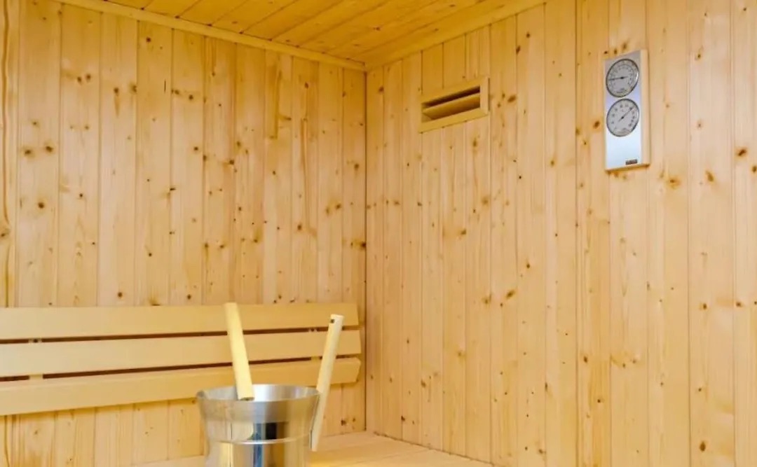 Wood-panelled sauna with a bucket and ladle