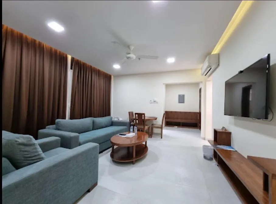 Executive Suite living room with a long sofa, dining table and wall-mounted TV
