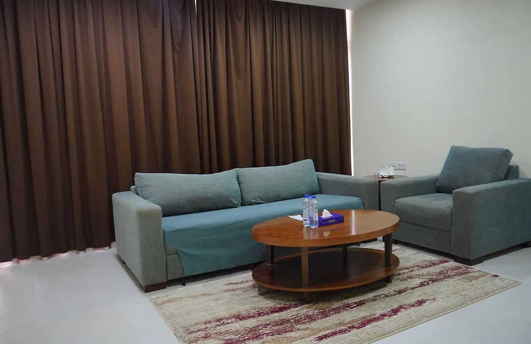 Junior Suite living room with a teal sofa and coffee table