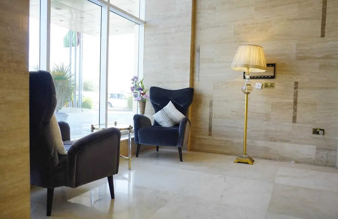 Superior Suite sitting area with an armchair beside a tall window