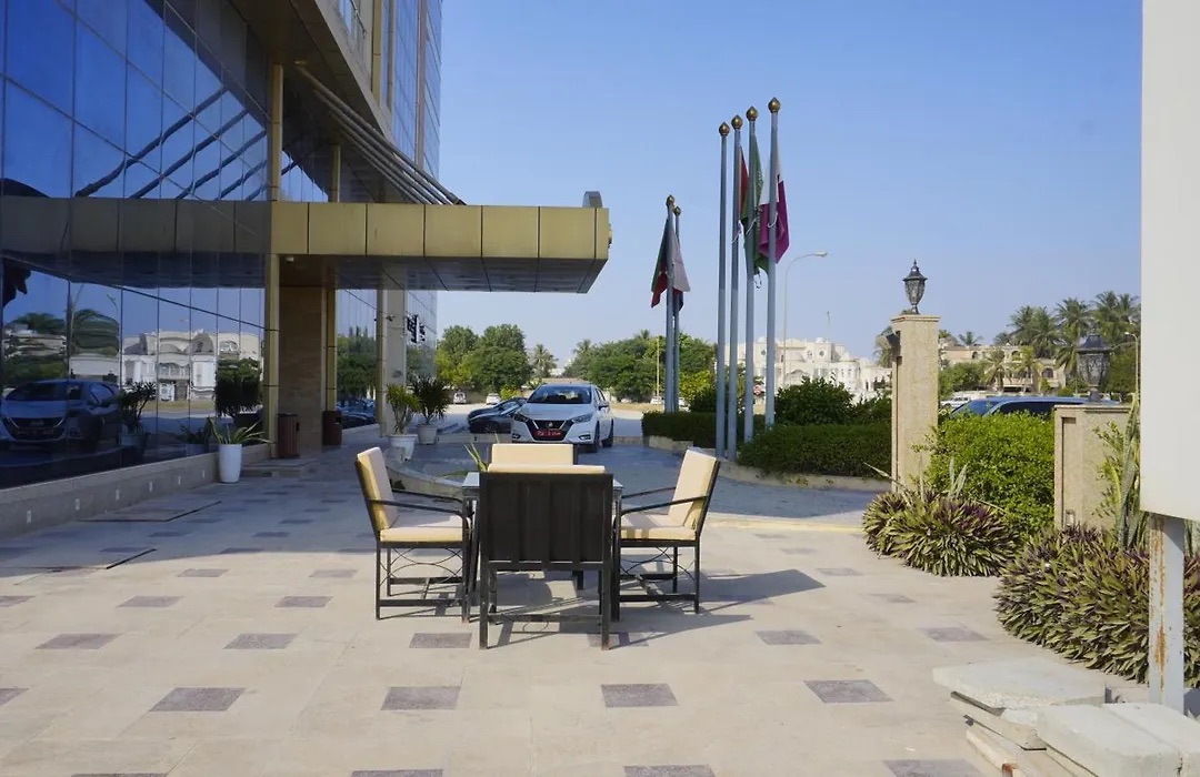 Outdoor terrace with tables and chairs beside the hotel entrance